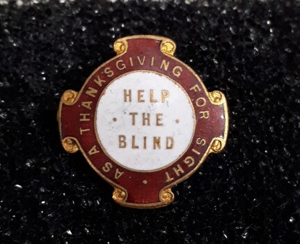 Red and white badge with gold edging