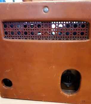 Rear view of leather covered box with rattan air flow grill and ports for cords