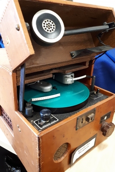Leather covered box with flip top and turntable with two heads for inscribing and reading, metal speaking tube and various knobs and levers