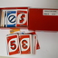 UNO playing cards with braille embossed on top left-hand and bottom right-hand corners in red cardboard box.