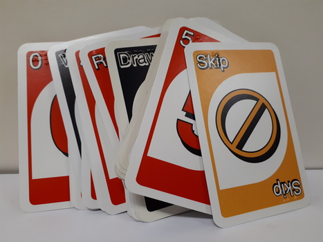 UNO playing cards with braille embossed on top left-hand and bottom right-hand corners.