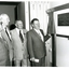 Four men in suits looking at plaque