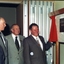 Four men in suits looking at plaque