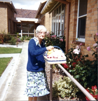 Older woman holding a basket of flowers