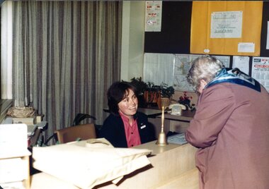 Woman at reception speaks to female signing in