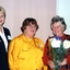 Edna Allen holds flowers as Di Kerr and another volunteer stand beside her