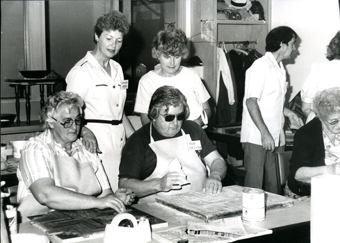 A female staff member shows a visitor activities in the craft room