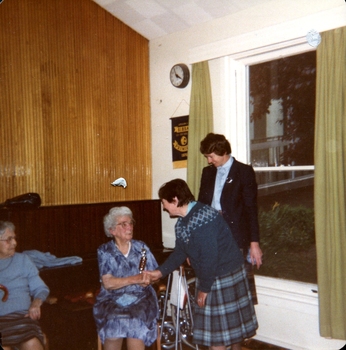 Woman in kilt shakes hand of an older woman