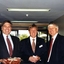 Three men standing in corridor dressed in suits
