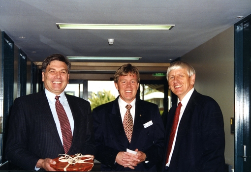 Three men standing in corridor dressed in suits