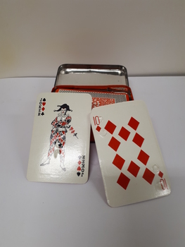Playing cards with red, black and white design with moon type at top left-hand and bottom right-hand corners in orange metal hinged box.
