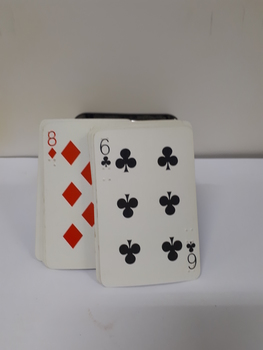 Playing cards with red, black and white design with braille embossing at top left-hand and bottom right-hand corners in (red or blue) metal hinged box.