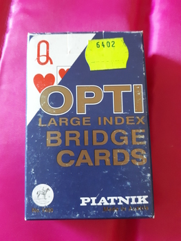 laying cards with red and white design with numbers and suit in large print in paper packet.