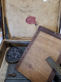 Well used suitcase with wooden and metal boards and metal pegs