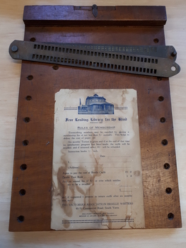 Brown rectangular wooden board with hinged paper clamp
