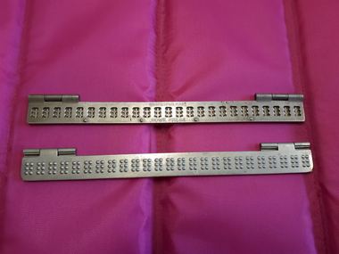 Two pieces of metal with Braille openings and two hinges at top