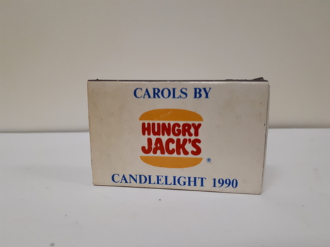 White box with Hungry Jacks logo and blue 'Carols by Candlelight 1990' above and below