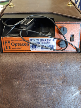 Orange box with 2 dials and 1 button with a small camera attached by cable to the box