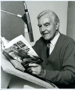 Narrator James Condon in audio studio with a book