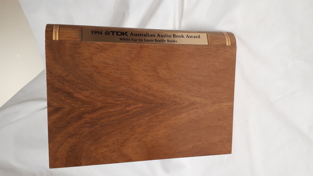 Wooden cassette box with title of award and name of book on spine