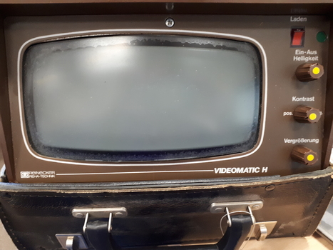 Small television screen in black case, with long rectangular cabinet.