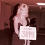 Blonde haired woman behind microphone in evening dress
