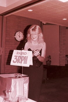 Blonde woman in evening dress, behind the microphone
