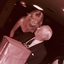 Blonde woman handing John Wicking a wrapped present