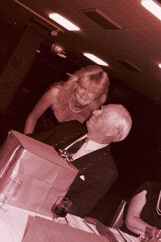 Blonde woman handing John Wicking a wrapped present
