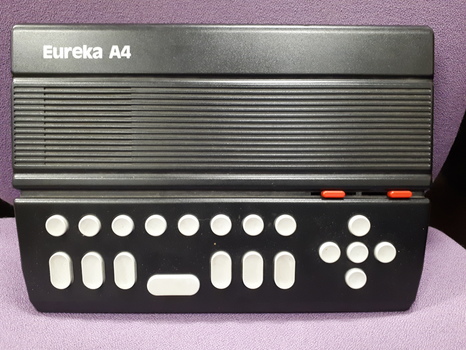 Black rectangular box with seven braille keys, five directional keys and eight command keys in light gray