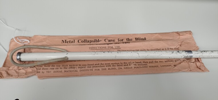 Close up view of handle and top of cane on paper envelope