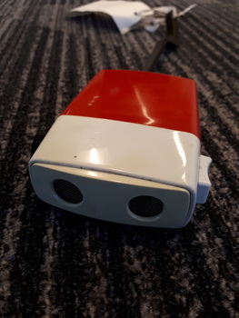 Red and white rectangular box with two circles at top and button on side