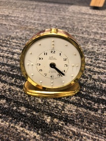 Gold clock with white time face