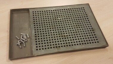 Silver rectangular metal tray with square containing grid for pegs.