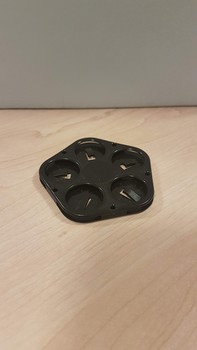 Black pentagon with five round holes in each corner