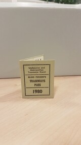 Light green or gray cardboard rectangle followed in half with "Melbourne and Metropolitan Tramways Board Blind Person's Tramway Pass 1980" in black writing