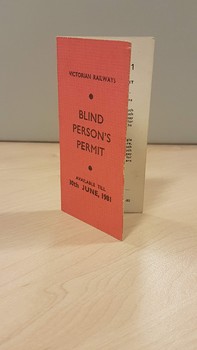 Pale red cardboard rectangle folded in half with black writing on front and inside