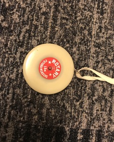 Cream disk with measuring tape inside and red label