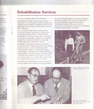 Man with a white cane uses a sighted guide.  A deaf blind man communicates with a male staff member.