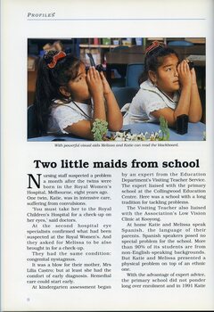 Melissa and Katie Castro hold magnifiers to their eyes as they at a table in a classroom.