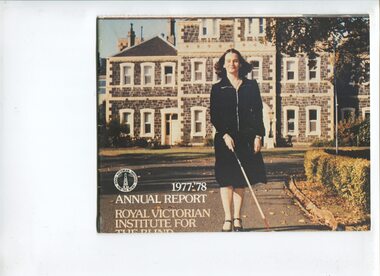 Woman walking with long cane in front of St Kilda Road building