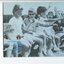 Group of children sitting on a bench, cheering at a sports event