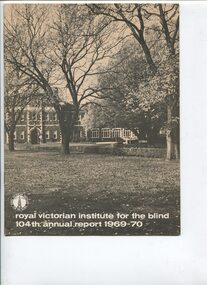 Photograph of front of building looking across grassed area through trees