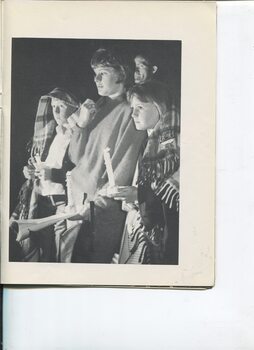 A family of three stand wrapped in blankets at Carols by Candlelight