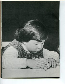 A young girl models clay on a table