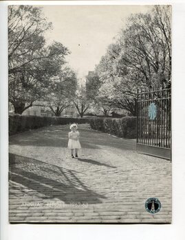 Young girl standing in between open gates at St Kilda Road