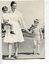 Nurse holds the hand of a boy whilst another sits on her hip at Burwood