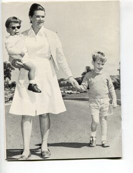 Nurse holds the hand of a boy whilst another sits on her hip at Burwood