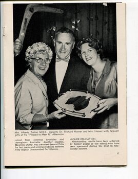 Alberta Tutton hands a tray to Mrs Hoover whilst Dr Hoover holds a boomerang overhead