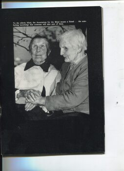 Two elderly women hold hands outside at nighttime